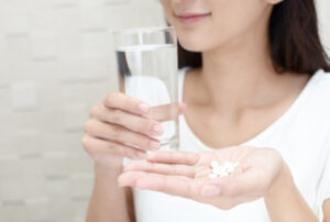 薬と水を持つ女性